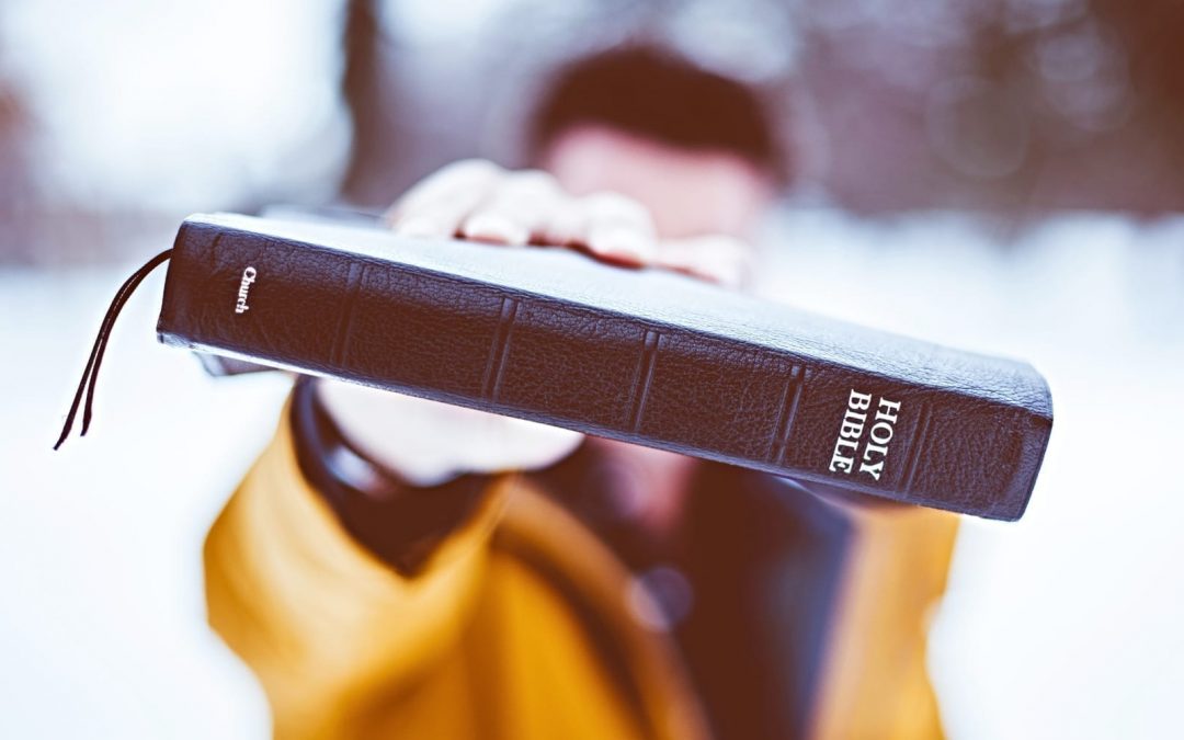 A man holding up a Bible