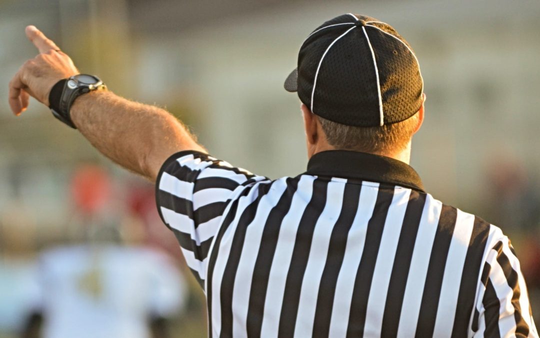 A football referee pointing during a game