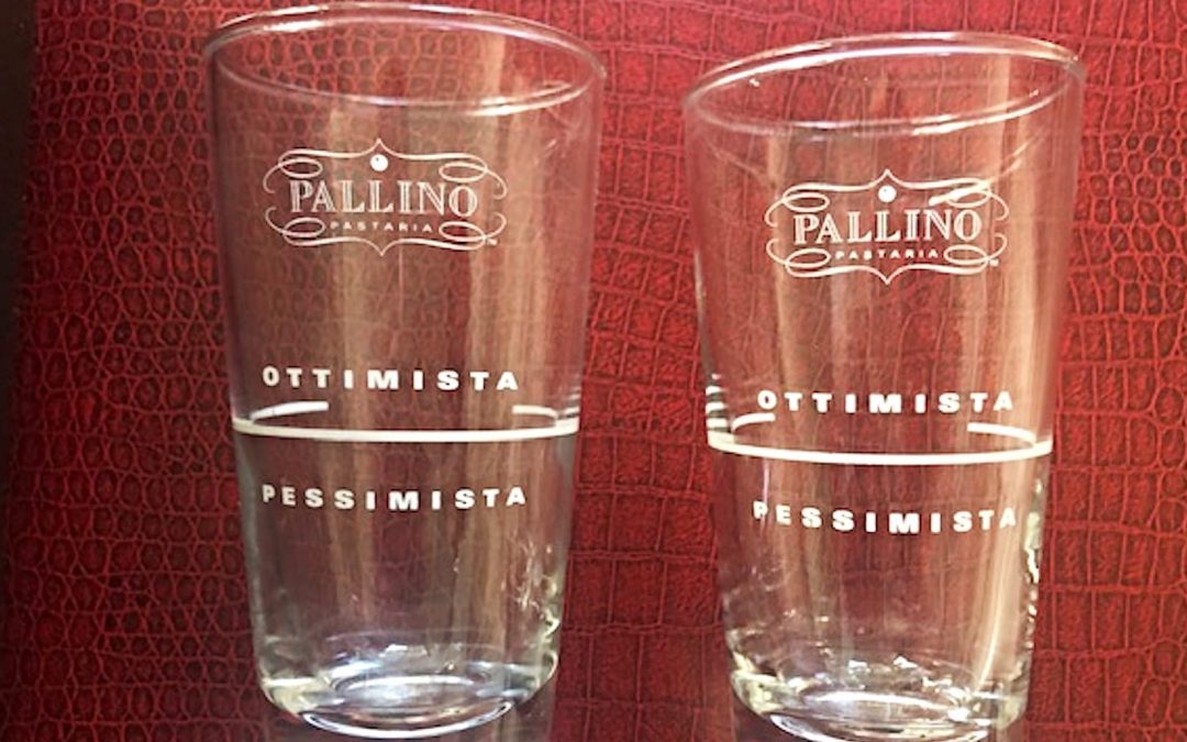 Two clear glasses with a red background