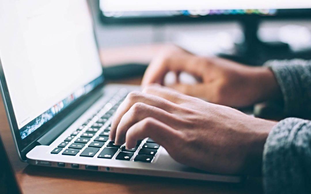 Close-up of hands typing on laptop computer