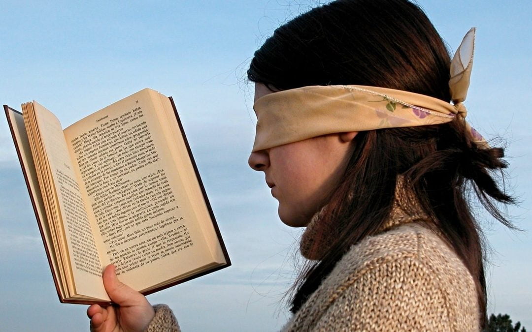 Blindfolded girl holding open book