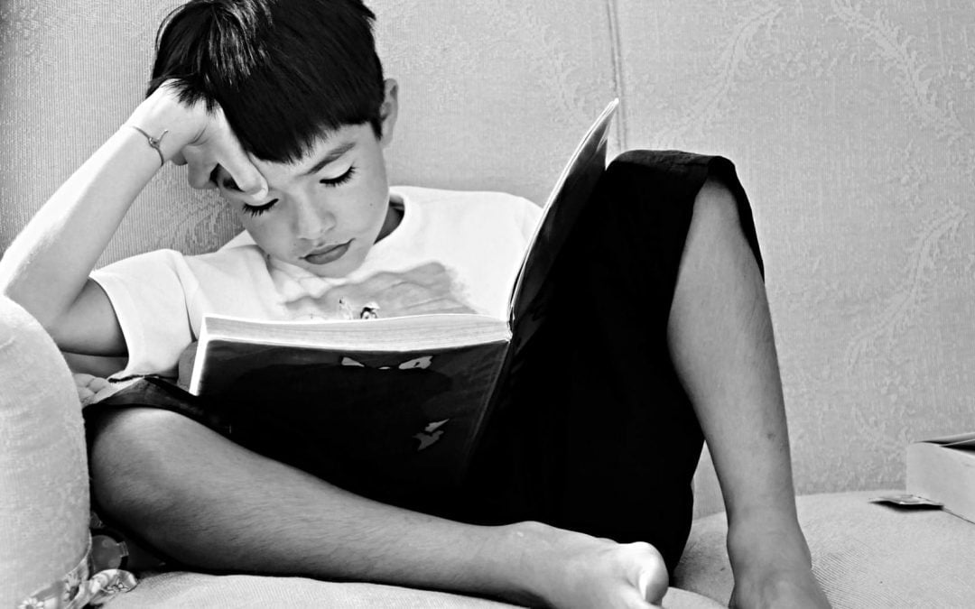 Boy on couch reading book