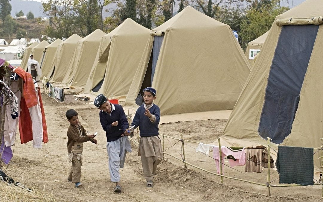 Boys in refugee camp with tents