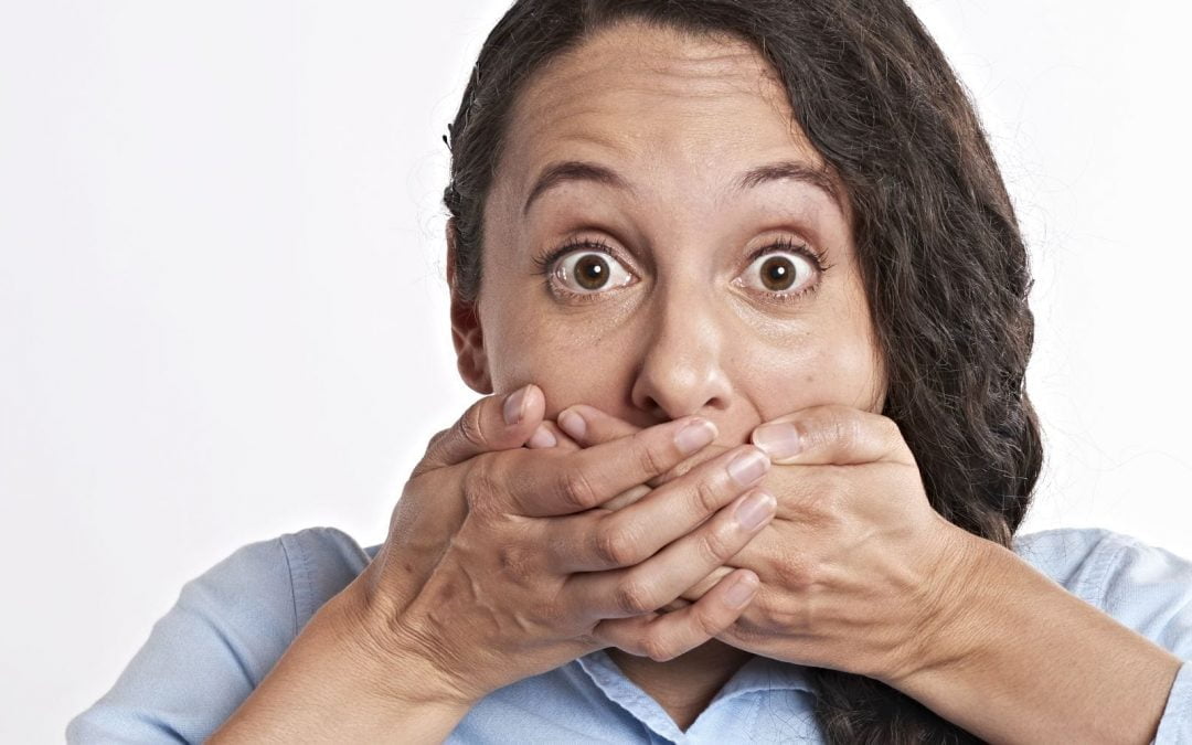 Woman covering mouth with both hands