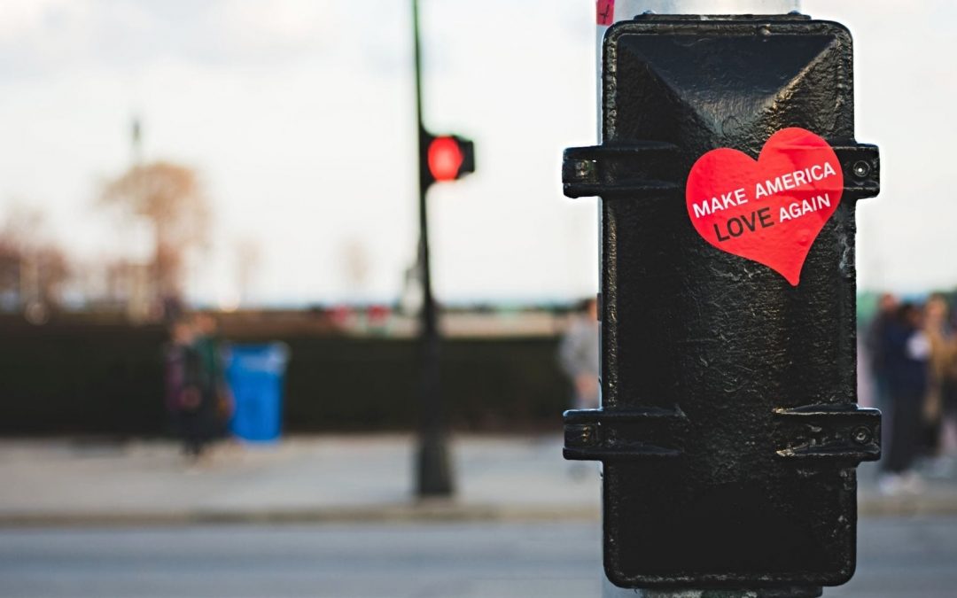 Heart sticker reading Make America Love Again on street pole