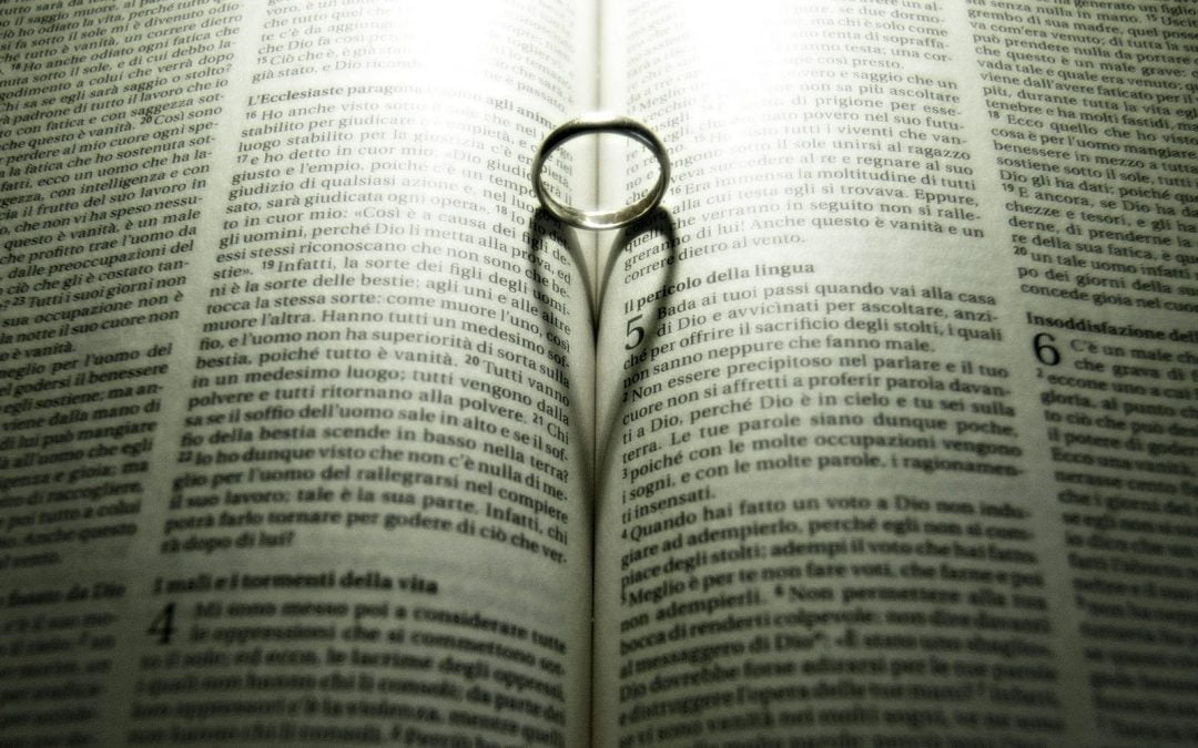 Ring casting heart shadow on pages of Bible